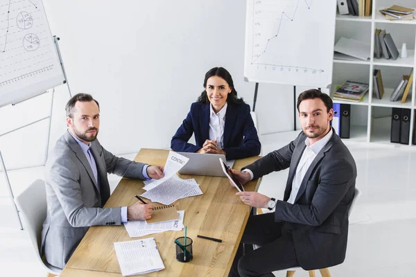 Empresarios Sentados Mesa Oficina Mirando Cámara —  Fotos de Stock