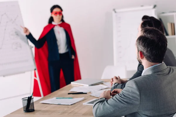 マスクとオフィスのビジネスマンのプレゼンテーションを示す岬のスーパー女性実業家 — ストック写真