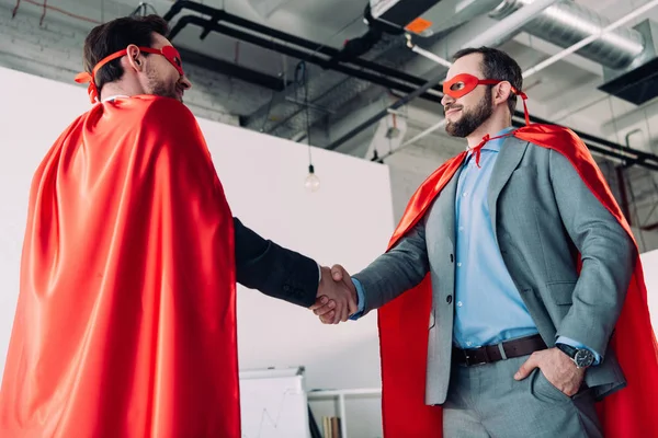 Vista Ángulo Bajo Guapos Súper Hombres Negocios Máscaras Capas Estrechando — Foto de Stock