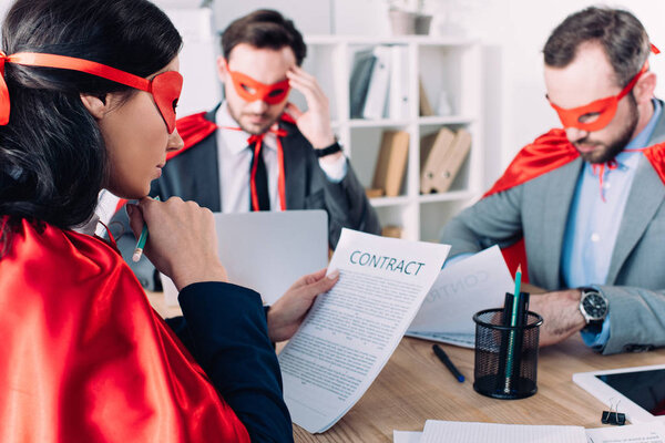 super businesspeople in masks and capes working in office