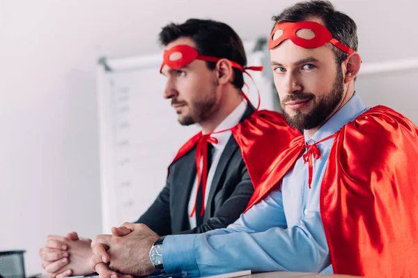 Gutaussehende Superunternehmer Masken Und Umhängen Sitzen Tisch Büro — Stockfoto