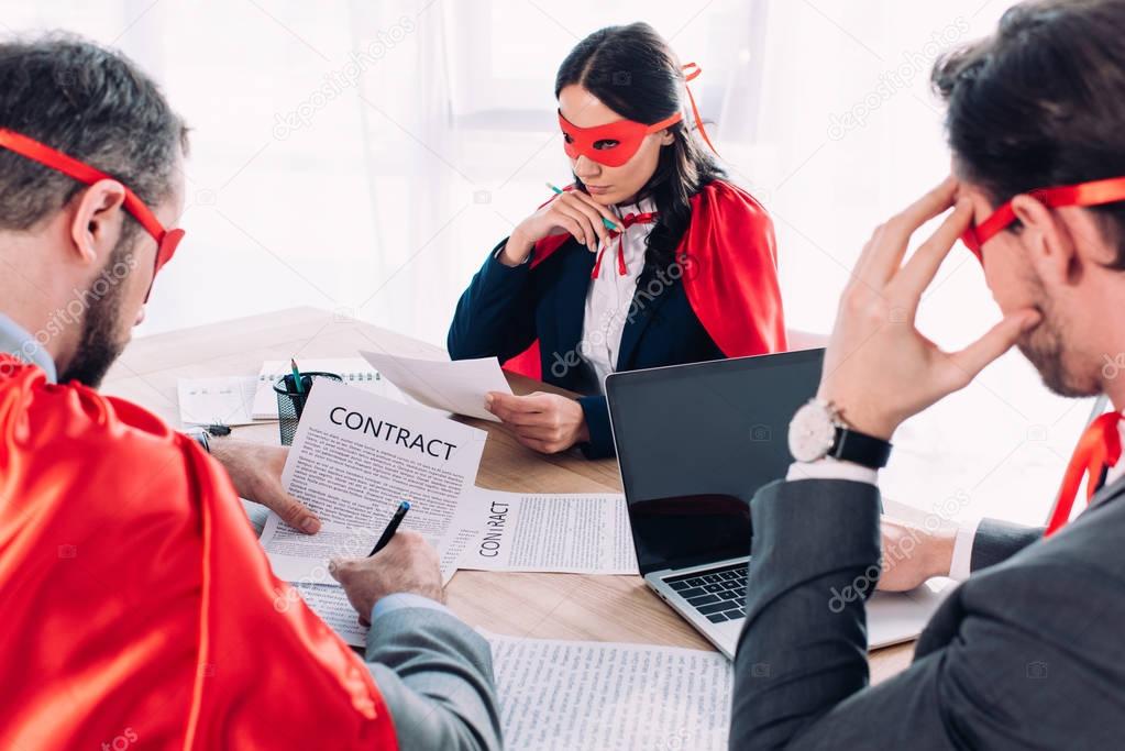 super businesspeople in masks and capes at brainstorm in office