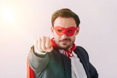 handsome super businessman in mask and cape showing fist isolated on white clipart