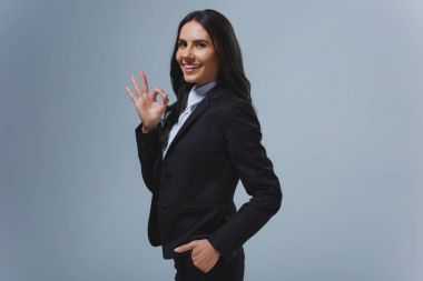 çekici işkadını gösteren iyi jest gri izole gülümseyen