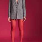 Cropped view of woman wearing red tights and grey jacket on red background