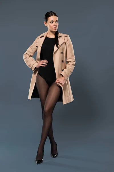 Mulher Posando Meia Calça Preta Trincheira Bege Fundo Escuro — Fotografia de Stock