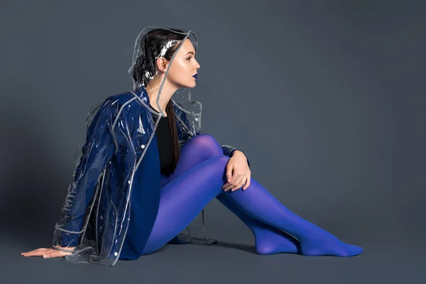 Stylish Woman Blue Tights Transparent Raincoat Sitting Dark Background — Stock Photo, Image