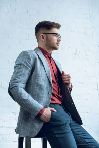 Stylish Man Casual Clothes Sitting Front Brick Wall — Free Stock Photo