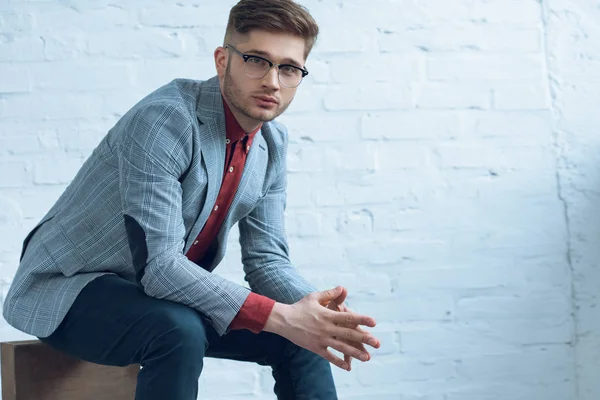 Atractivo Hombre Barbudo Con Traje Gafas Sentado Frente Pared Ladrillo — Foto de Stock