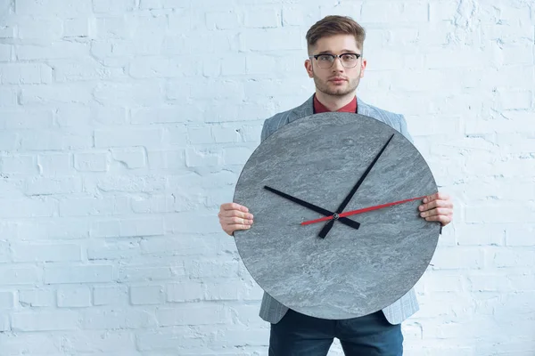 Homme Tenant Une Grande Horloge Devant Lui Par Mur Blanc — Photo