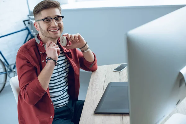 Lykkelig Frilanser Mann Med Hodetelefoner Sittende Ved Arbeidsbordet – stockfoto