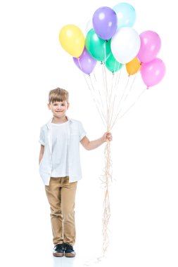 renkli balonlar tutarak ve üzerinde beyaz izole kamera gülümseyen sevimli küçük çocuk