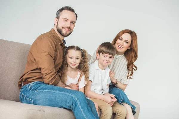 快乐的家庭 两个孩子坐在沙发上 微笑着在灰色的相机 — 图库照片