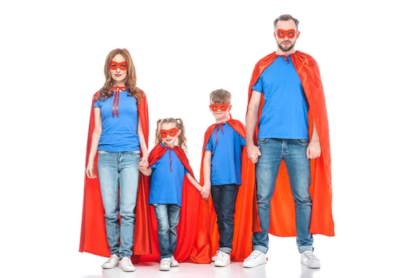 super family in masks and cloaks holding hands and looking at camera isolated on white