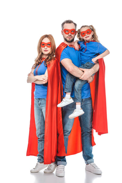 parents with little daughter pretending to be superheroes and looking at camera isolated on white