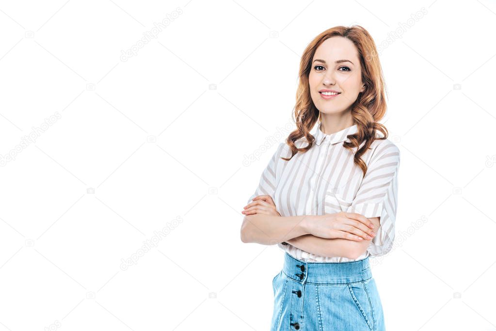 portrait of beautiful woman standing with crossed arms and smiling at camera isolated on white