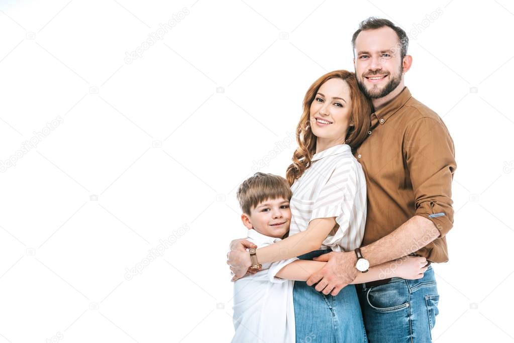 happy parents with adorable little son hugging and smiling at camera isolated on white