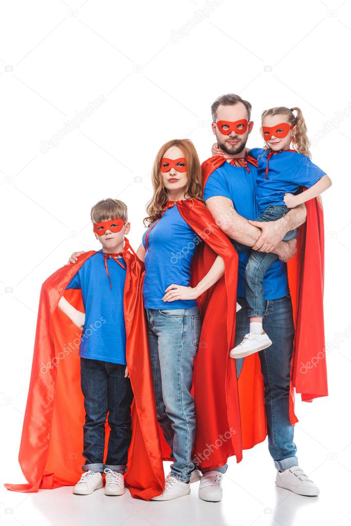 super family in masks and cloaks standing together and looking at camera isolated on white 