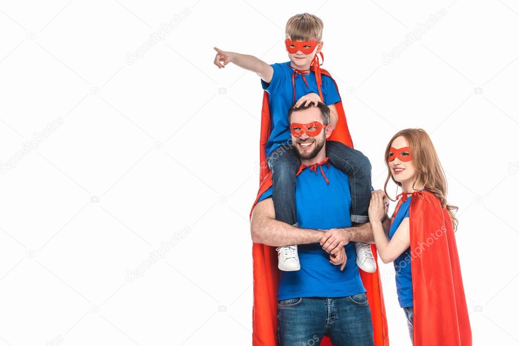 super family in masks and cloaks smiling and looking away isolated on white