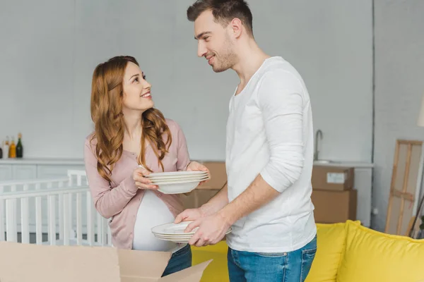 Happy Pregnant Couple Holding Dishware Smiling Each Other New House — Stock Photo, Image