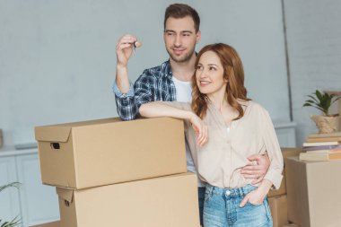 portrait of smiling couple looking at keys from new apartment, relocation concept clipart
