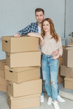 gülümseyen iki yeni ev, yer değiştirme concept, karton kutular yığını üzerine eğilerek
