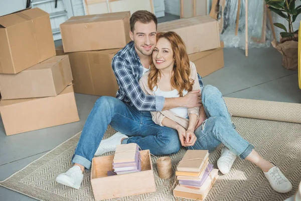 Feliz Jovem Casal Sentado Juntos Sorrindo Para Câmera Enquanto Embala — Fotografia de Stock