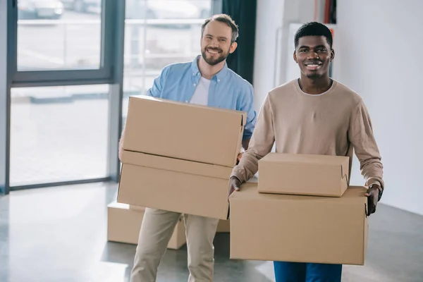 Happy Multiethnic Men Holding Cardboard Boxes Smiling Camera Relocation — Stock Photo, Image