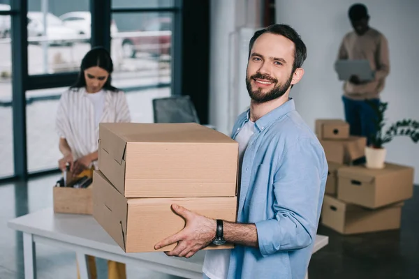 Hombre Sosteniendo Cajas Cartón Sonriendo Cámara Mientras Muda Con Sus — Foto de Stock