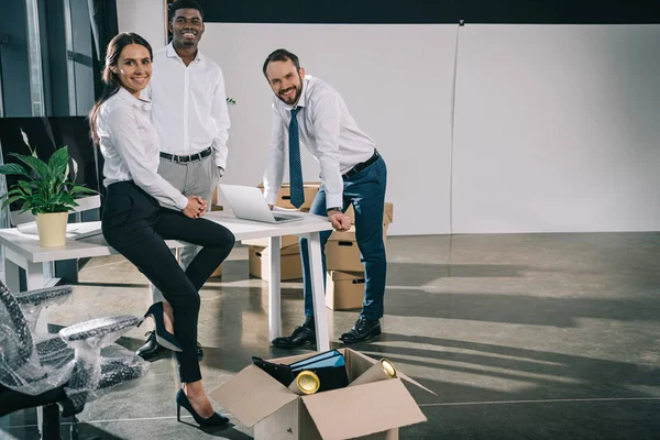 Colegas Multiétnicos Felizes Sorrindo Para Câmera Enquanto Move Novo Escritório — Fotografia de Stock