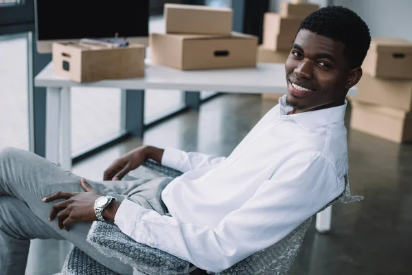 Feliz Joven Afroamericano Hombre Negocios Sonriendo Cámara Mientras Está Sentado —  Fotos de Stock