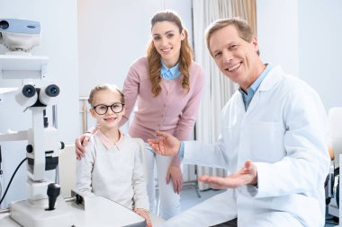Anne ve yeni gözlük göz doktoruna Oda danışmanlık kamerada bakarak mutlu kızı