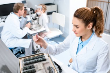 meslektaşım çocuk ile görme alanı test incelenmesi sırasında deneme çerçevesi için lensler ile kadın göz doktoru