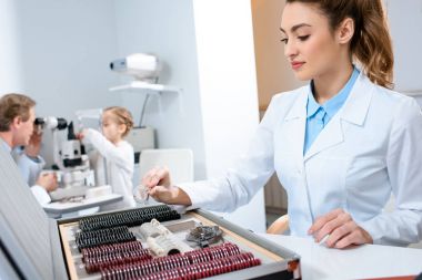 meslektaşım çocuk ile görme alanı test incelenmesi sırasında deneme çerçevesi için lensler ile kadın göz doktoru