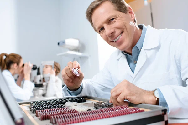 Masculino Sorrindo Oftalmologista Segurando Lentes Para Quadro Experimental Enquanto Colega — Fotografia de Stock