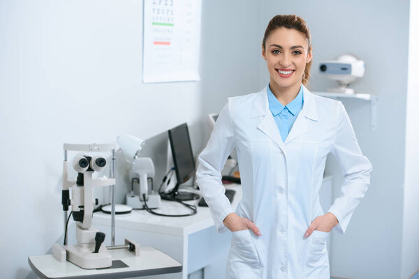 улыбающаяся женщина-оптометрист позирует в оптической клинике
