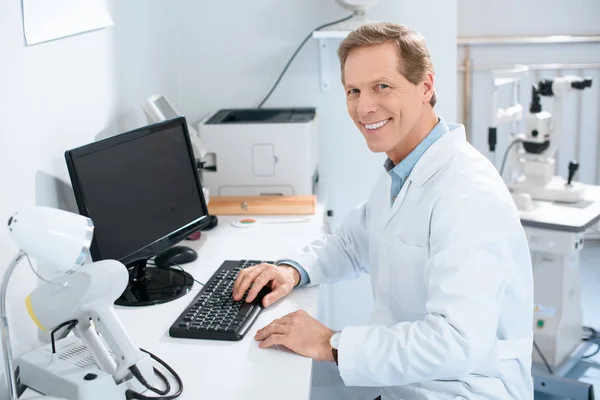 Bonito Sorridente Masculino Oftalmologista Trabalhando Com Computador Clínica — Fotografia de Stock