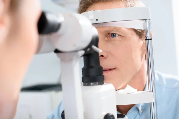 Οφθαλμίατρος Εξετάζει Άνθρωπος Σύγχρονο Οπτικό Εξοπλισμό — Φωτογραφία Αρχείου