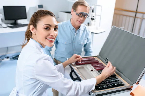 Female Optician Examining Middle Aged Man Eyes Trial Frame Lenses — Stock Photo, Image