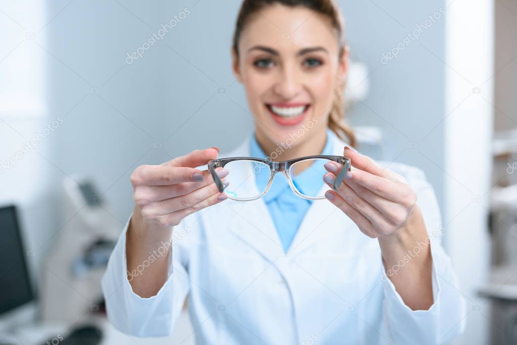 selective focus of female oculist holding eyeglasses