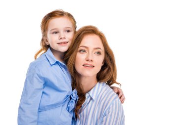 güzel kızıl saçlı anne ve gülümseyen ve uzağa bakarak kızı beyaz izole