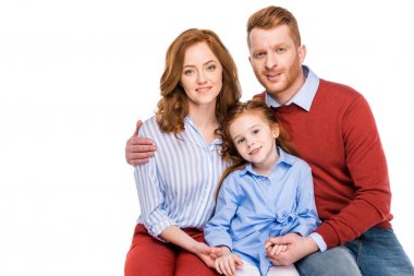 bir çocukla birlikte oturan ve üzerinde beyaz izole kamera gülümseyen güzel mutlu aile