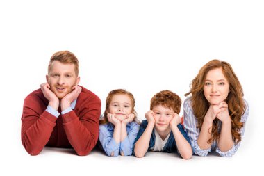yan yana yatarken ve üzerinde beyaz izole kamera gülümseyen mutlu Kızıl saçlı aile 