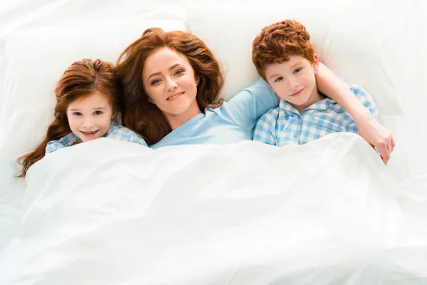 Κάτοψη Του Ευτυχισμένη Μητέρα Παιδιά Χαριτωμένο Κοκκινομάλλα Ξαπλωμένη Στο Κρεβάτι — Φωτογραφία Αρχείου