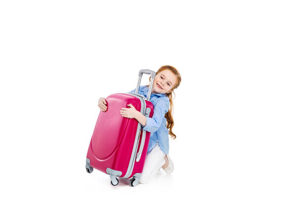 adorable happy child hugging pink suitcase isolated on white    