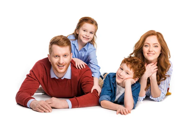 幸福的红头发的家庭与两个孩子躺在一起 微笑着在白色的相机隔离 — 图库照片