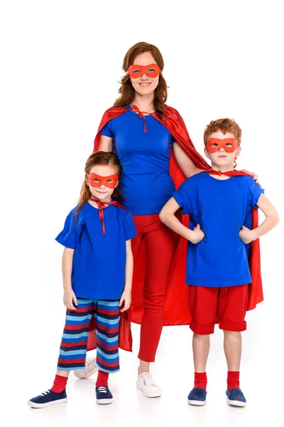 スーパー ヒーローの衣装一緒に立って 白で隔離カメラで笑顔のかわいい小さな子供を持つ母 — ストック写真