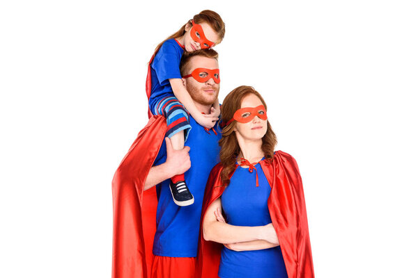 family of superheroes in masks and cloaks looking at camera isolated on white