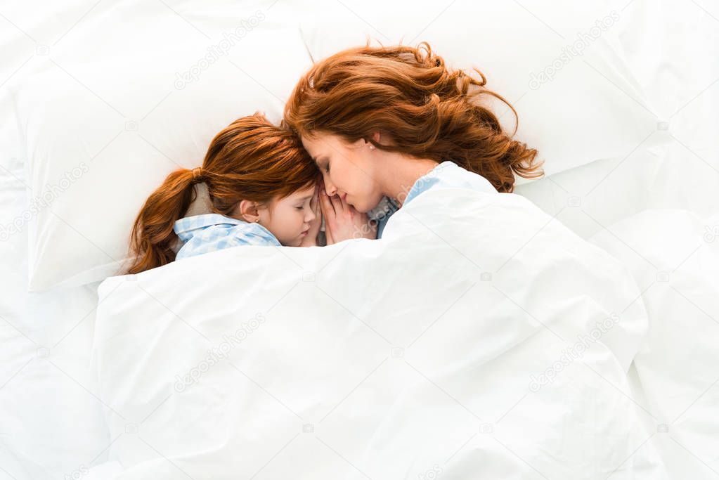 beautiful redhead mother and daughter sleeping together in bed