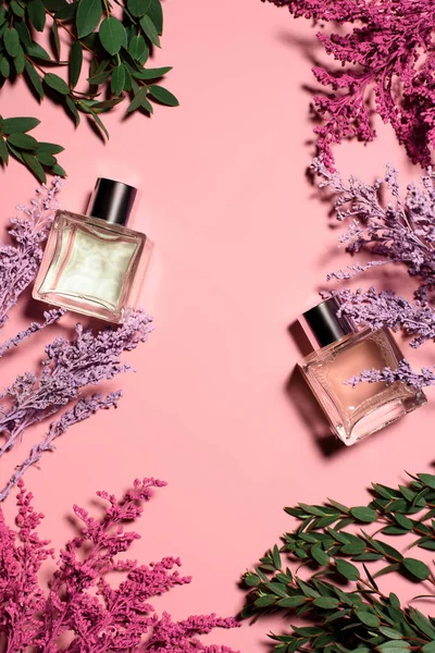 Draufsicht Auf Glasflaschen Mit Parfüm Mit Blumen Auf Rosa Oberfläche — Stockfoto